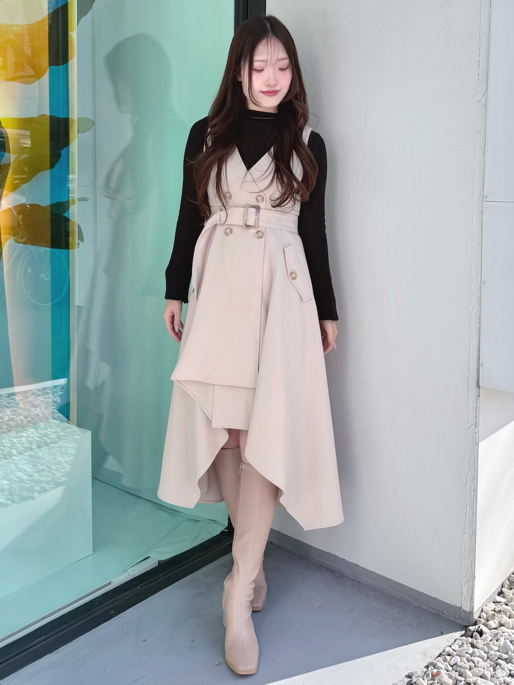 ベージュ系のワンピース、ベージュ系のブーツ、ベージュ系のトレンチコートを着用したレディースの冬コーディネートの6枚目の写真