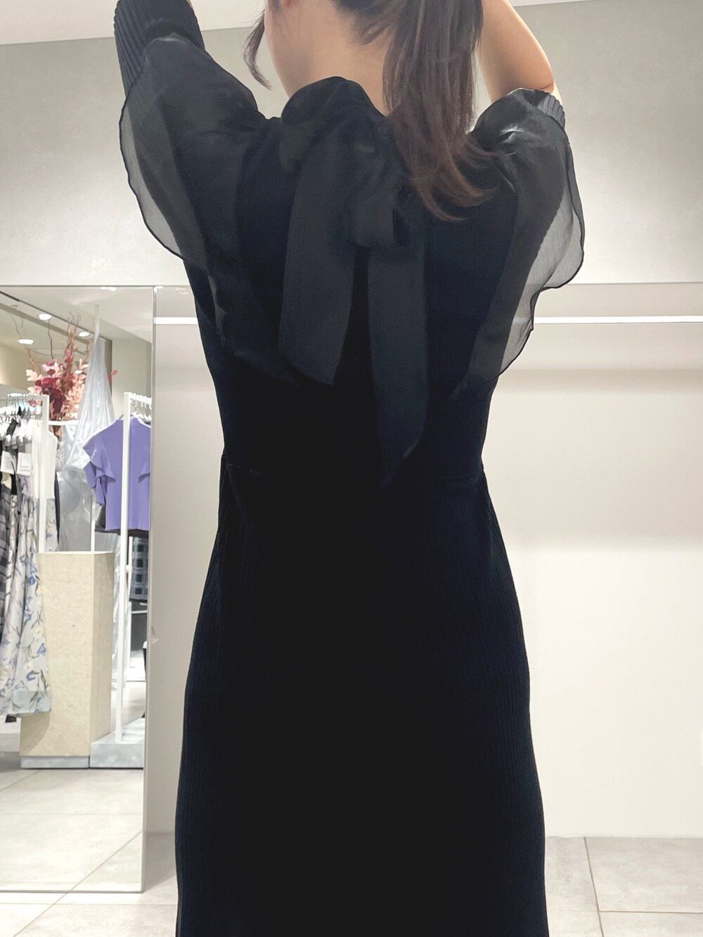 ブラック系のワンピース、ブラック系のハンドバッグ、ブラック系のブーツを着用したレディースの秋コーディネートの7枚目の写真