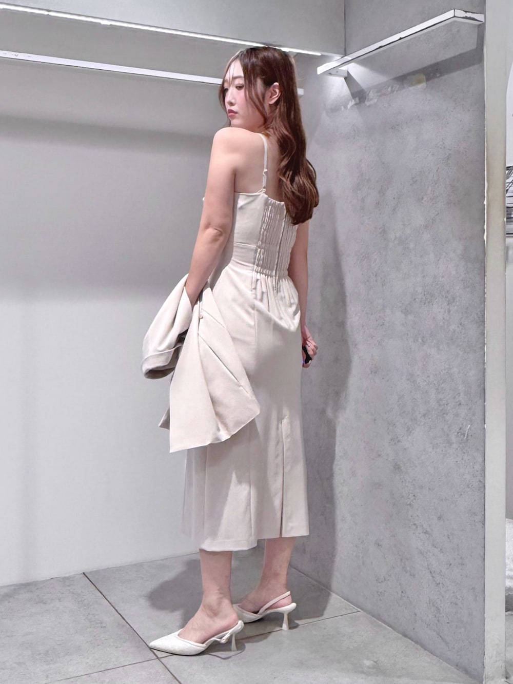 ベージュ系のベスト、ベージュ系のワンピース、ベージュ系のショルダーバッグを着用したレディースの夏コーディネートの7枚目の写真