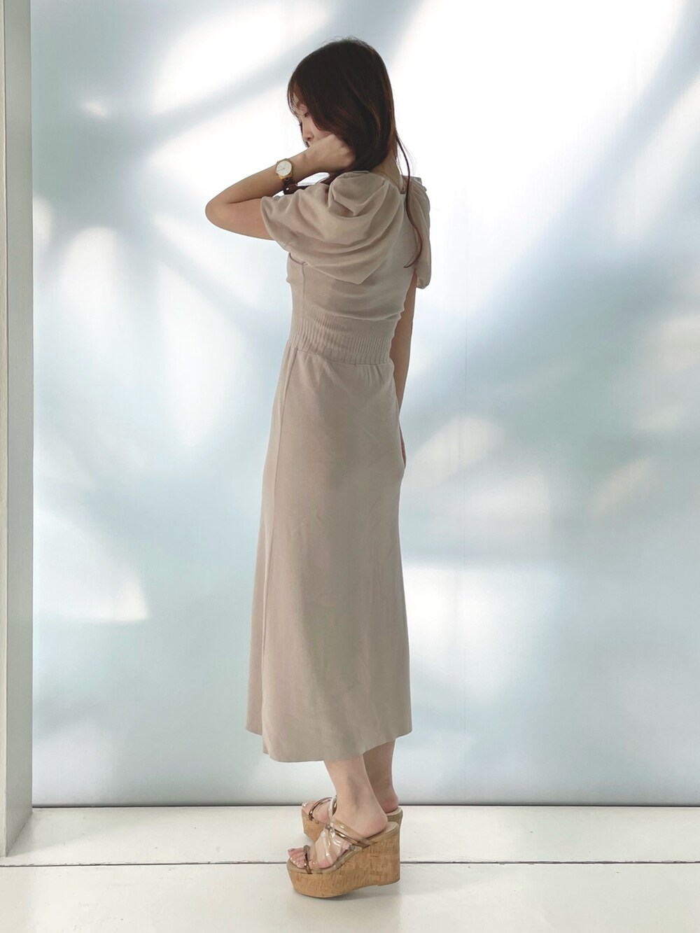 ベージュ系のワンピース、ブラウン系のサンダルを着用したレディースの春コーディネートの2枚目の写真