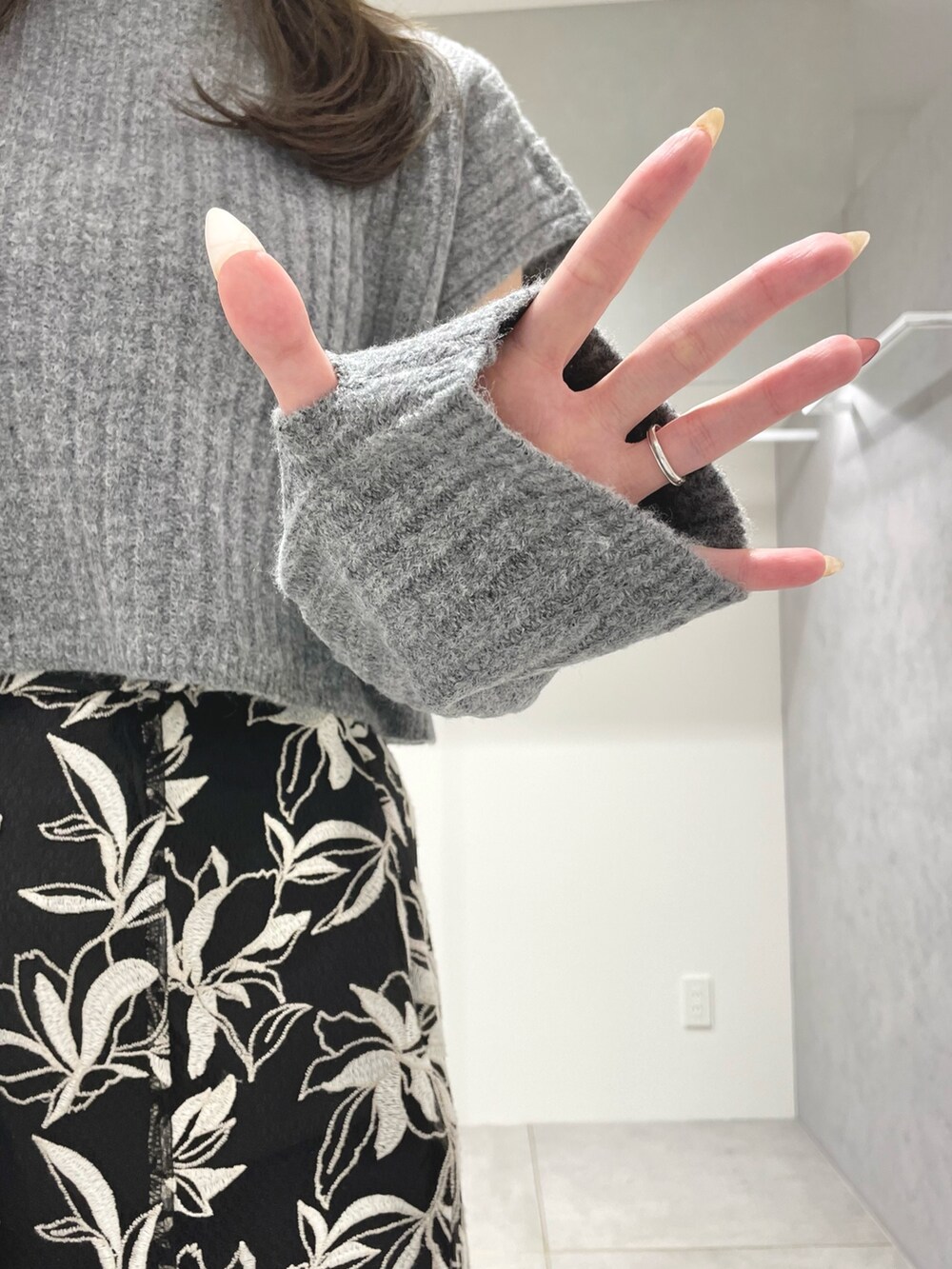 ブラック系のスカート、ブラック系のブーツ、グレー系のニット/セーターを着用したレディースの冬コーディネートの6枚目の写真