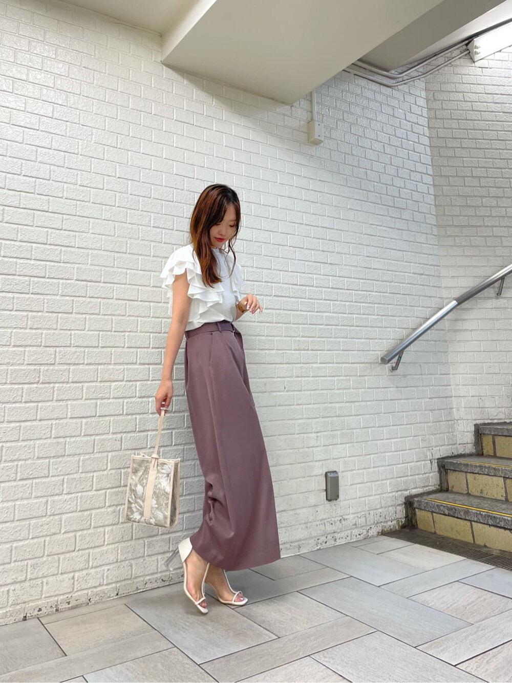 ホワイト系のその他シューズ、ホワイト系のシャツ/ブラウス、ベージュ系のハンドバッグを着用したレディースの秋コーディネートの3枚目の写真