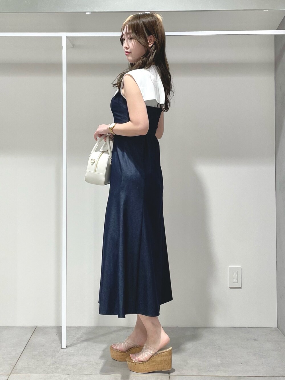 ホワイト系のボストンバッグ、ブルー系のワンピース、その他のサンダルを着用したレディースの春コーディネートの2枚目の写真