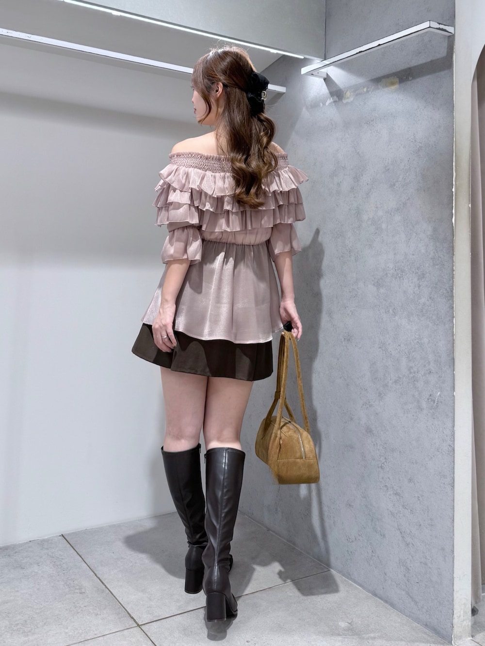 ピンク系のシャツ/ブラウス、ブラウン系のハンドバッグ、ブラウン系のブーツを着用したレディースの秋コーディネートの3枚目の写真