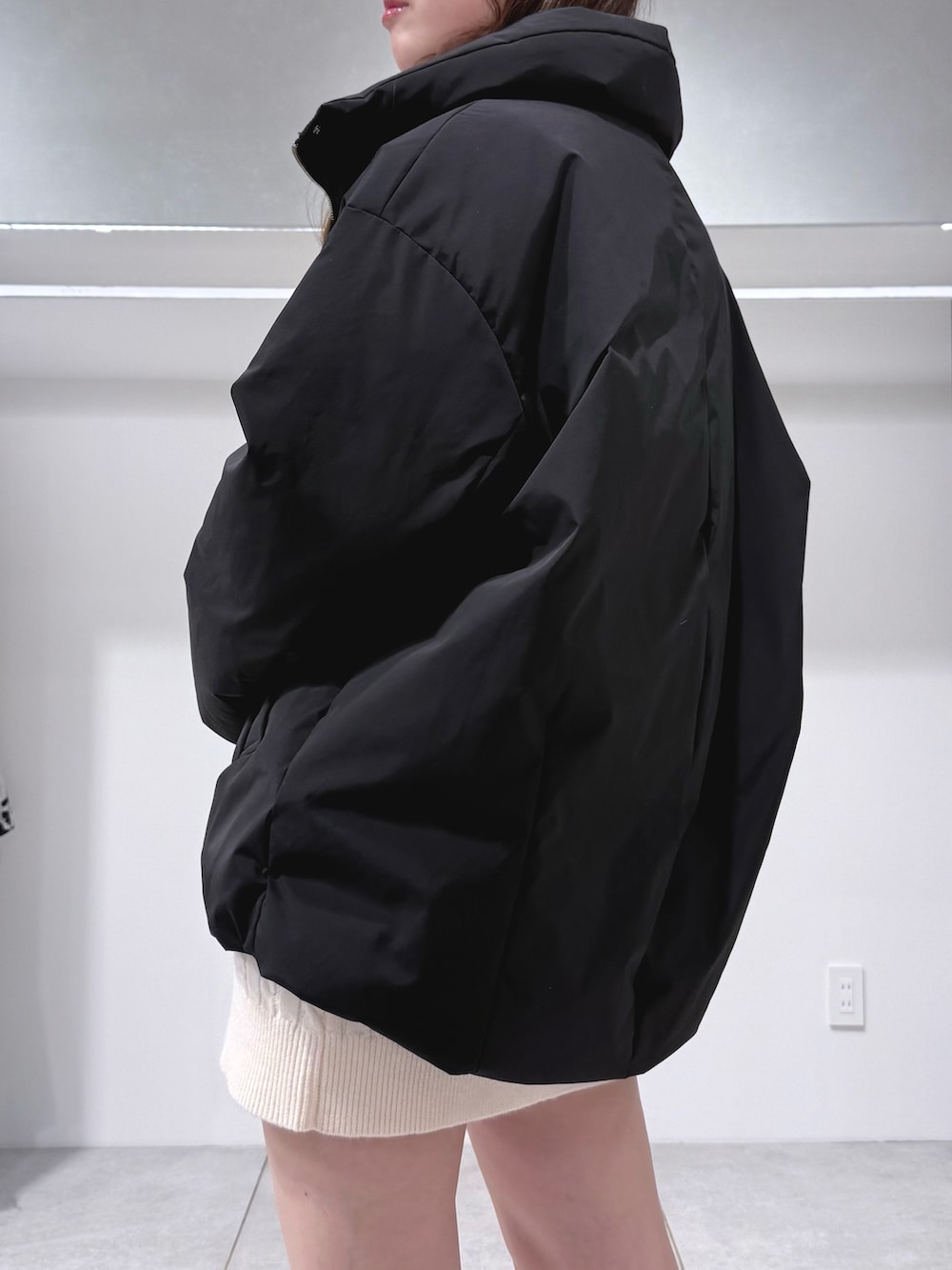 ホワイト系のワンピース、ブラウン系のブーツ、ブラック系のダウンジャケット/コートを着用したレディースの冬コーディネートの5枚目の写真