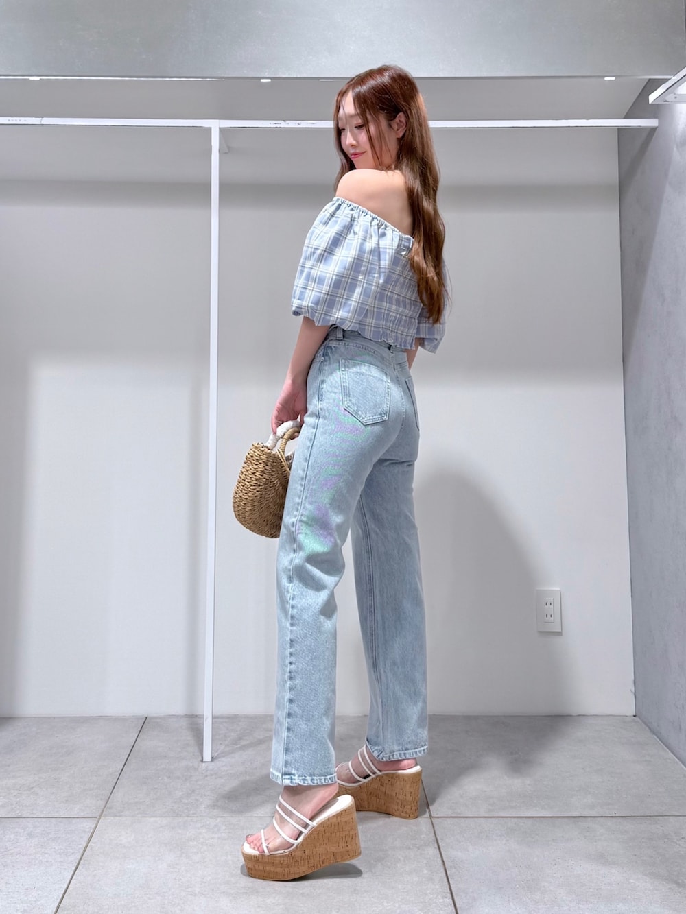 ブルー系のシャツ/ブラウス、ブルー系のデニムパンツ、ベージュ系のハンドバッグを着用したレディースの春コーディネートの2枚目の写真