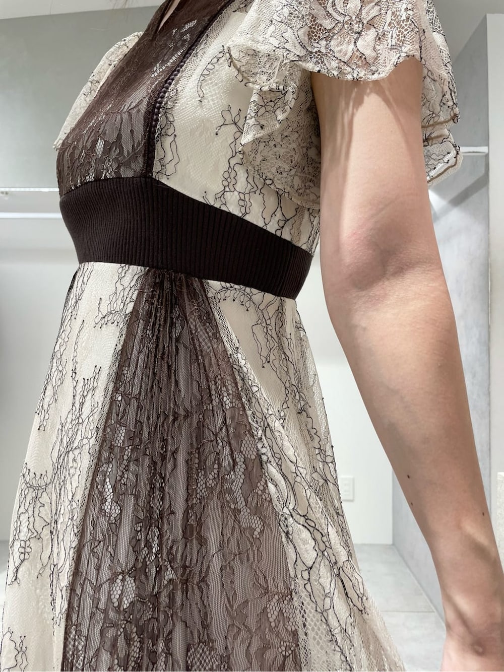 ブラック系のパンプス、ホワイト系のワンピース、ベージュ系のカーディガン/ボレロを着用したレディースの秋コーディネートの9枚目の写真