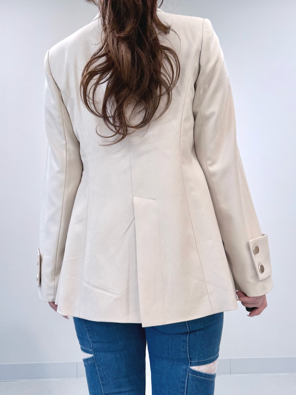 ブルー系のデニムパンツ、ホワイト系のテーラードジャケット、ホワイト系のシャツ/ブラウスを着用したレディースの春コーディネートの6枚目の写真