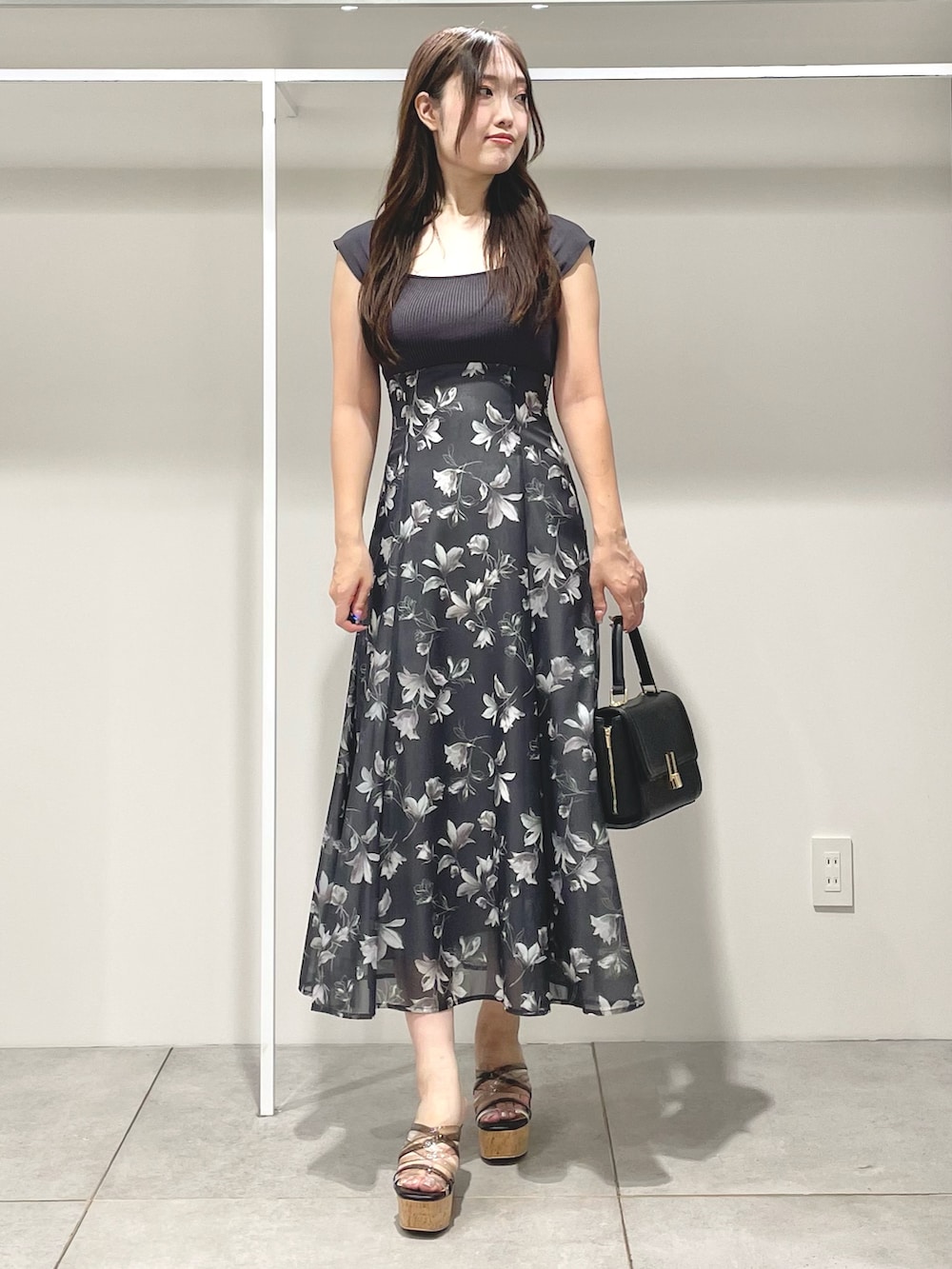 ブラック系のショルダーバッグ、ブラック系のサンダル、グレー系のワンピースを着用したレディースの夏コーディネートの2枚目の写真
