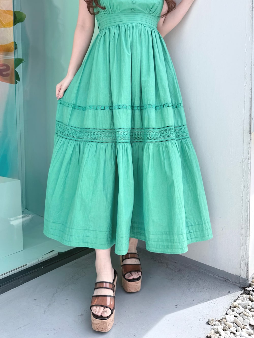 グリーン系のワンピース、ブラウン系のサンダル、ベージュ系のその他雑貨を着用したレディースの春コーディネートの7枚目の写真