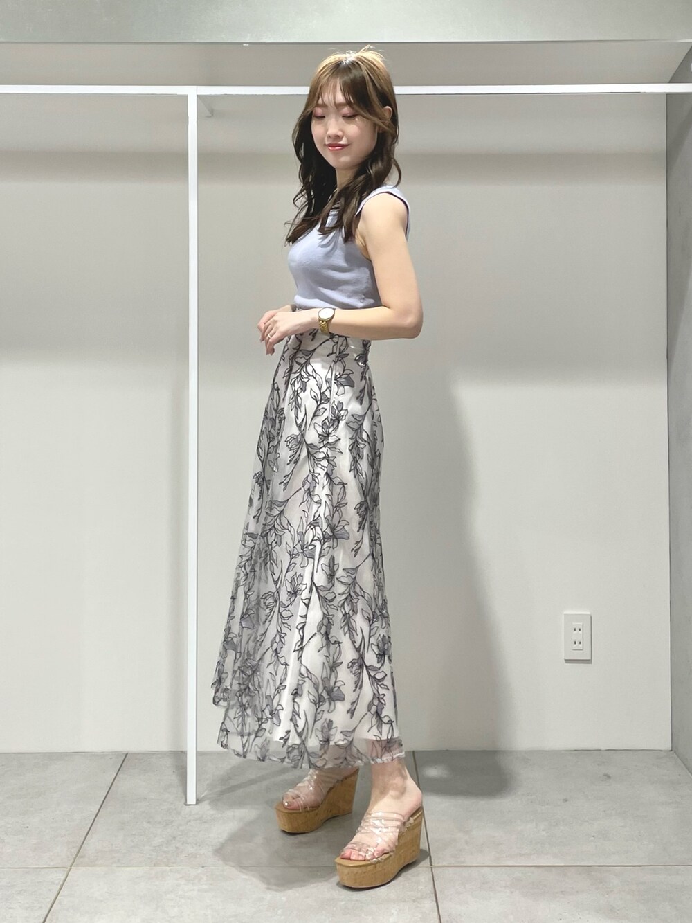 ブルー系のニット/セーター、グレー系のスカート、その他のサンダルを着用したレディースの春コーディネートの3枚目の写真