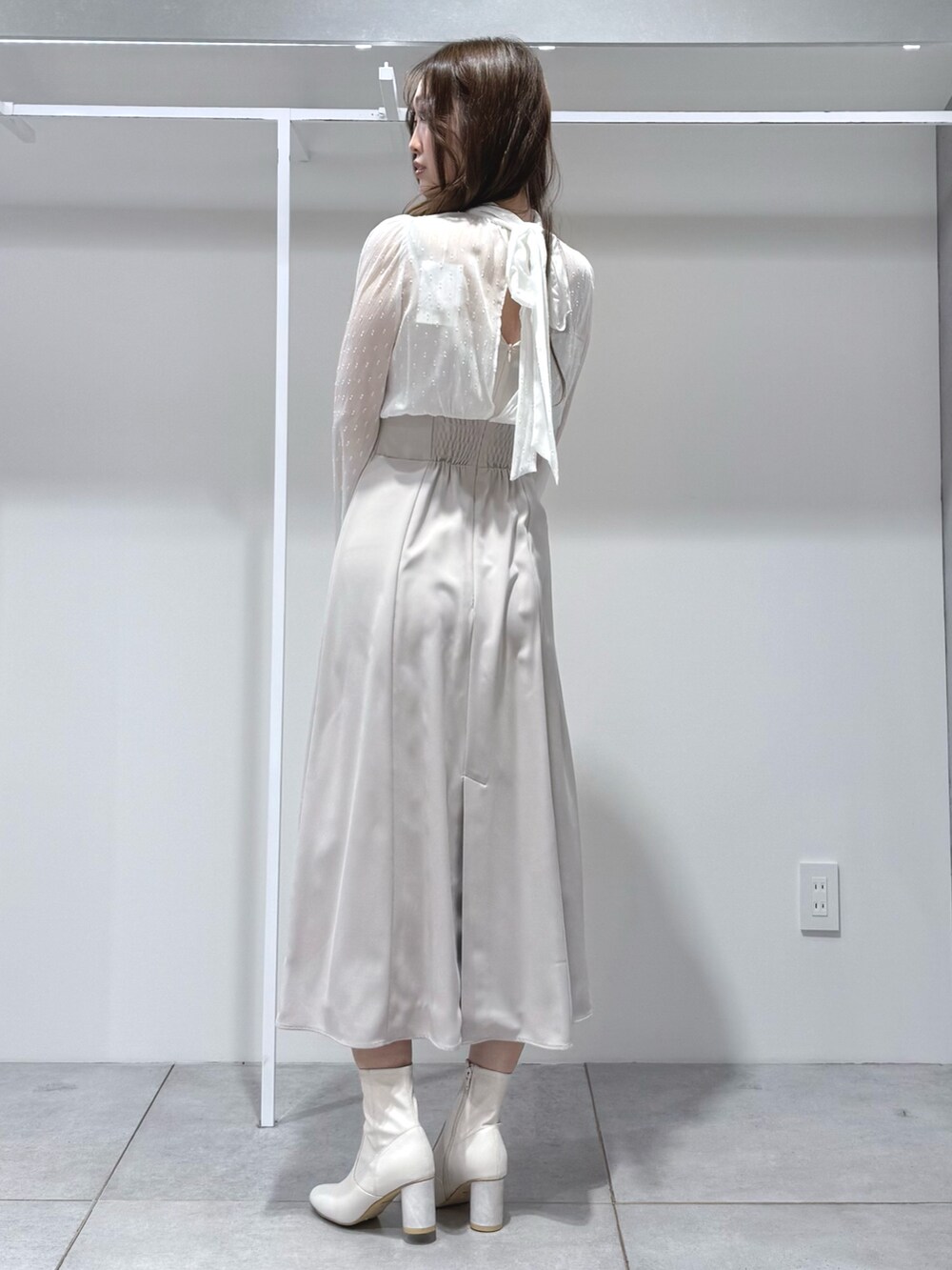 ベージュ系のその他アウター、ホワイト系のワンピース、ホワイト系のブーツを着用したレディースの冬コーディネートの7枚目の写真