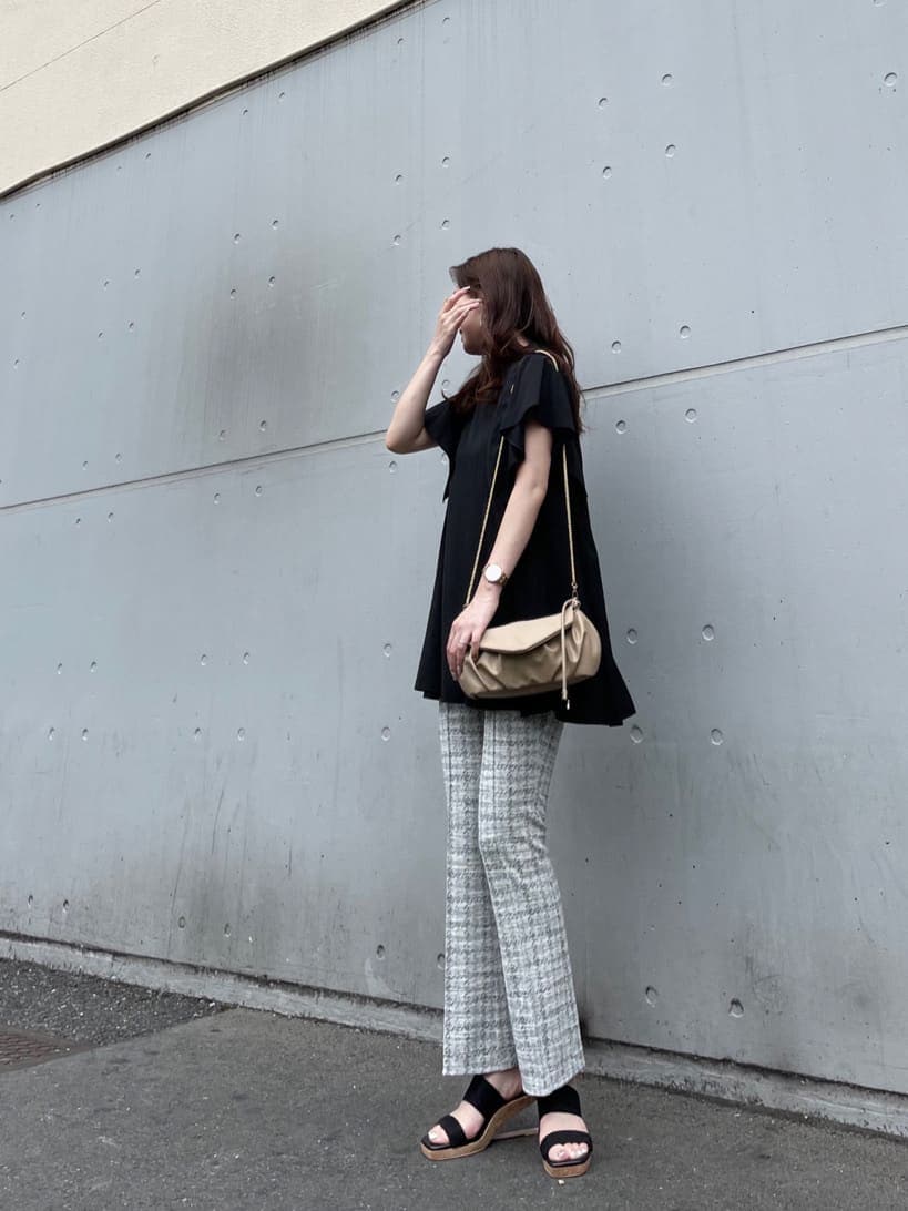 ブラック系のサンダル、ブラック系のシャツ/ブラウス、ホワイト系のクラッチバッグを着用したレディースの夏コーディネートの3枚目の写真