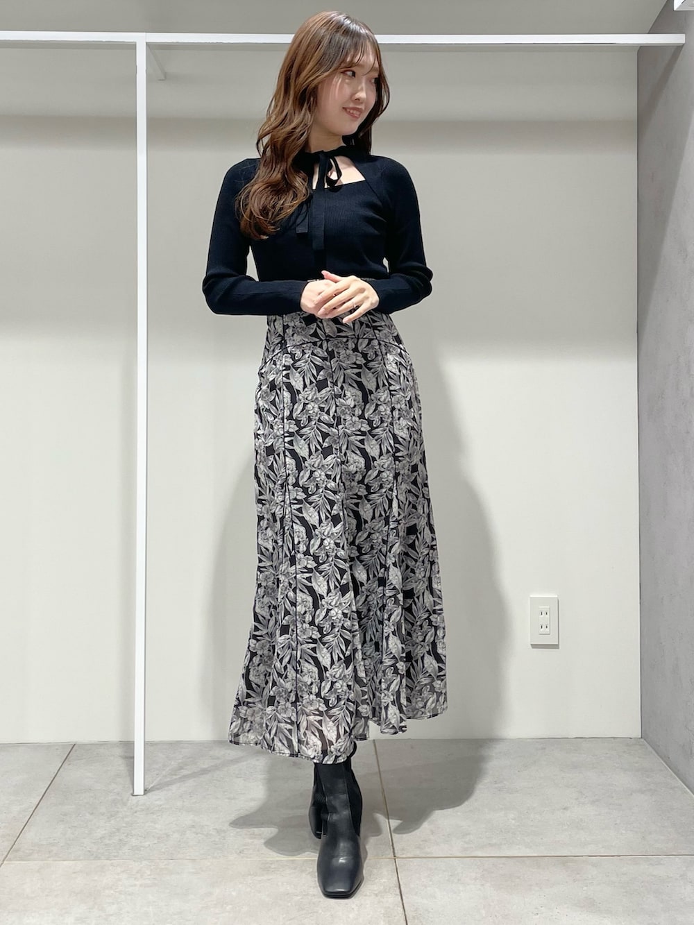 ベージュ系のチェスターコート、ブラック系のブーツ、ブラック系のスカートを着用したレディースの冬コーディネートの7枚目の写真