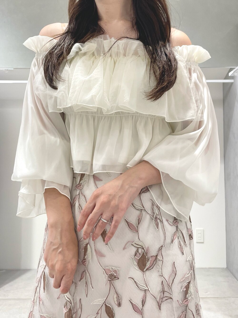 ホワイト系のシャツ/ブラウス、ピンク系のスカート、ベージュ系のパンプスを着用したレディースの夏コーディネートの6枚目の写真