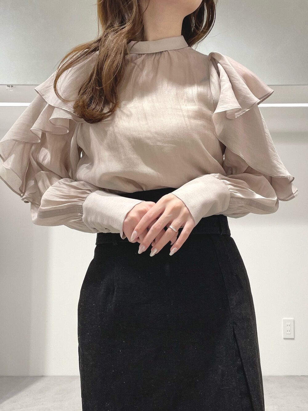 ベージュ系のシャツ/ブラウス、ブラック系のブーツ、ブラック系のスカートを着用したレディースの冬コーディネートの5枚目の写真