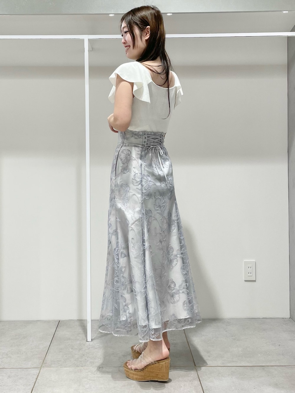 ホワイト系のニット/セーター、ブルー系のスカート、その他のサンダルを着用したレディースの春コーディネートの3枚目の写真