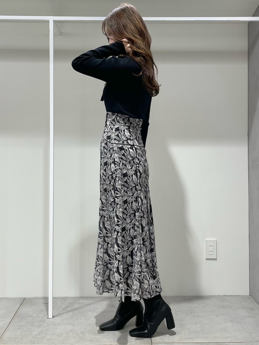 ベージュ系のチェスターコート、ブラック系のブーツ、ブラック系のスカートを着用したレディースの冬コーディネートの5枚目の写真