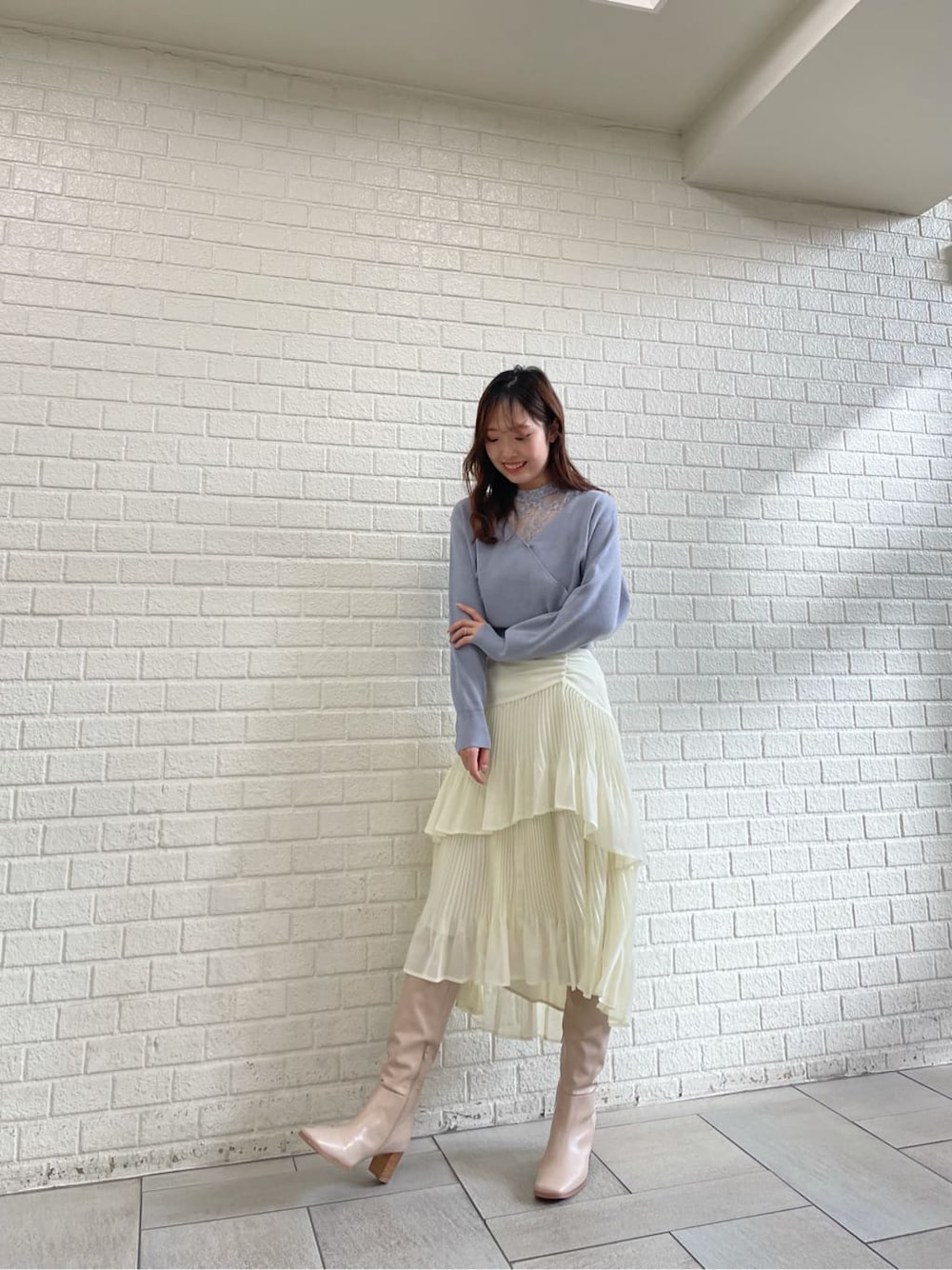 ベージュ系のブーツ、ブルー系のニット/セーター、ホワイト系のスカートを着用したレディースの冬コーディネートの4枚目の写真