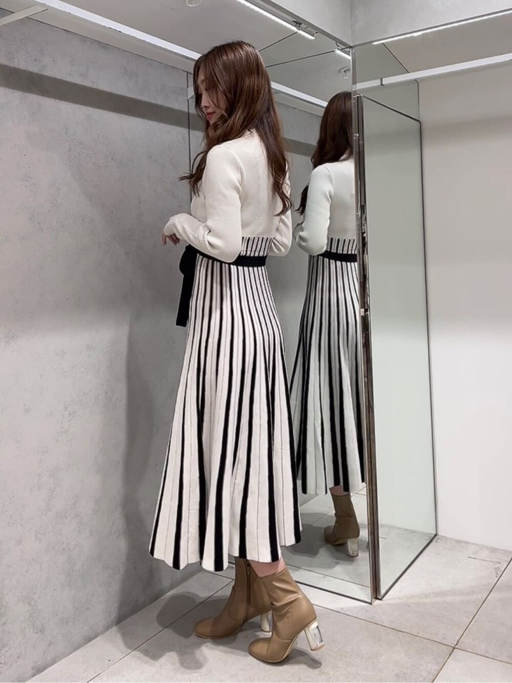 ベージュ系のトレンチコート、ベージュ系のトレンチコート、ホワイト系のワンピースを着用したレディースの秋コーディネートの6枚目の写真