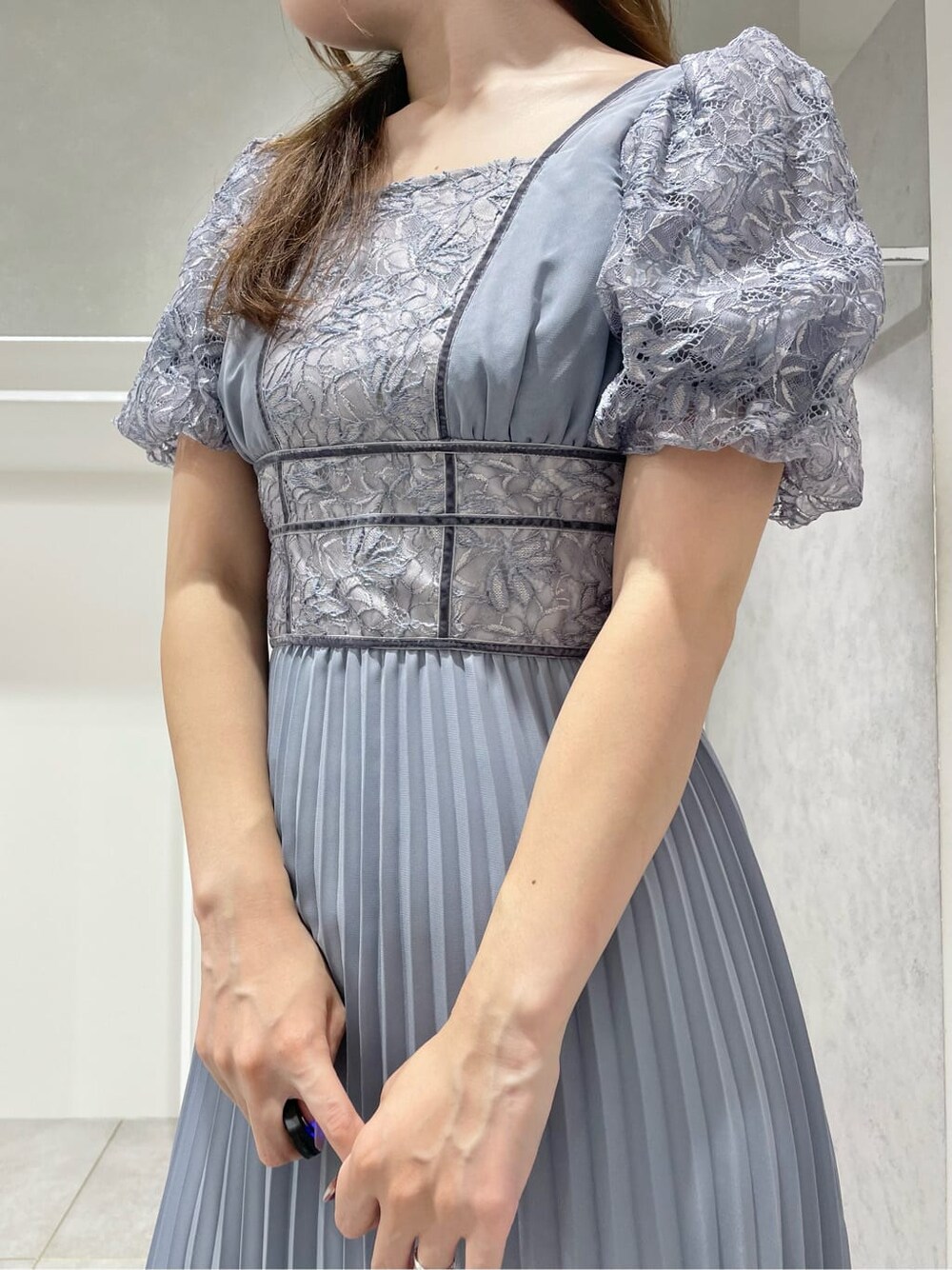 ブラック系のパンプス、ブルー系のワンピース、シルバー系のイヤリングを着用したレディースの秋コーディネートの5枚目の写真