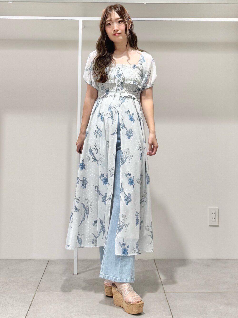 グレー系のワンピース、ブルー系のデニムパンツ、その他のサンダルを着用したレディースの春コーディネートの3枚目の写真