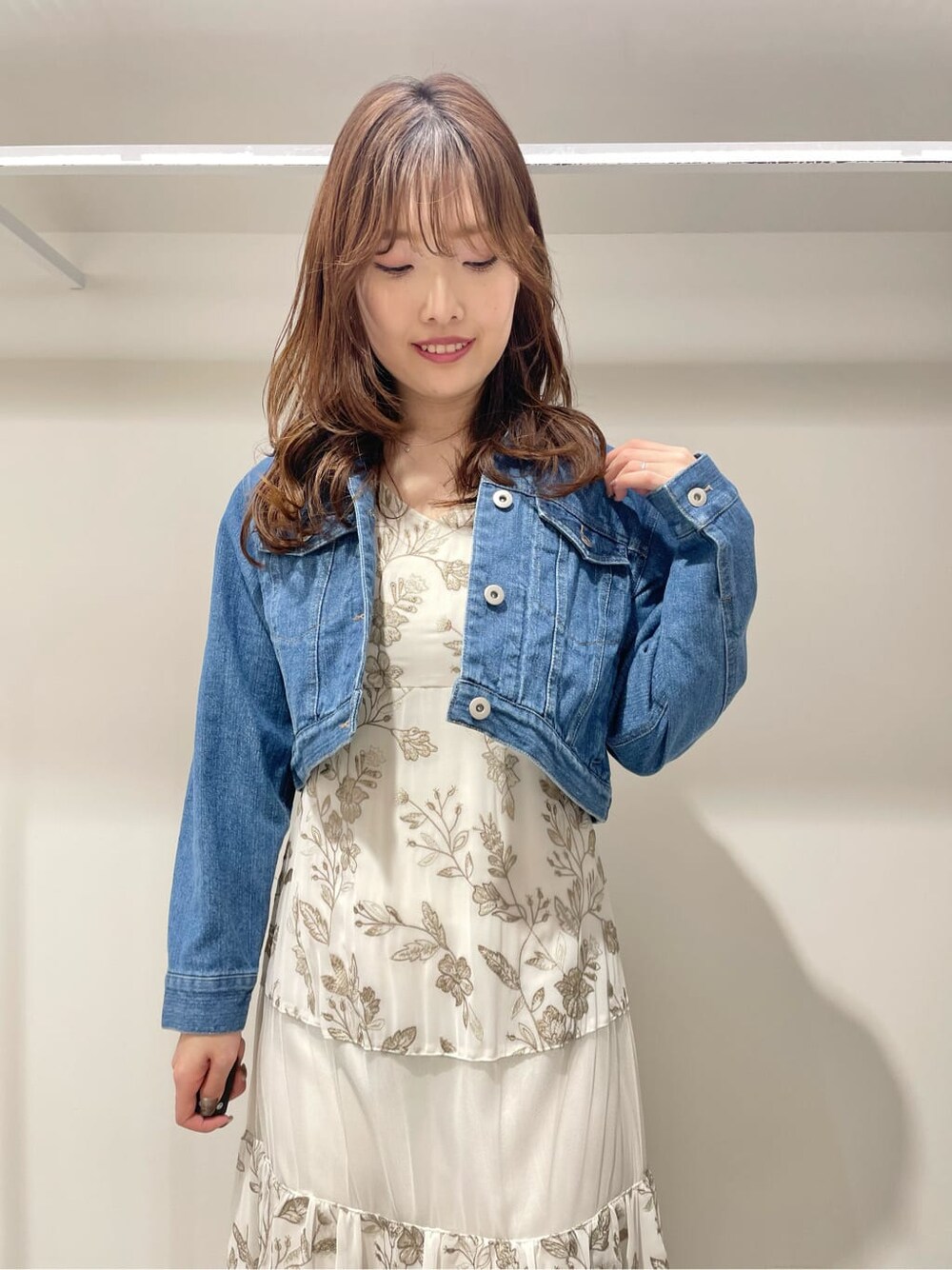 ブルー系のテーラードジャケット、ベージュ系のワンピースを着用したレディースの春コーディネートの3枚目の写真