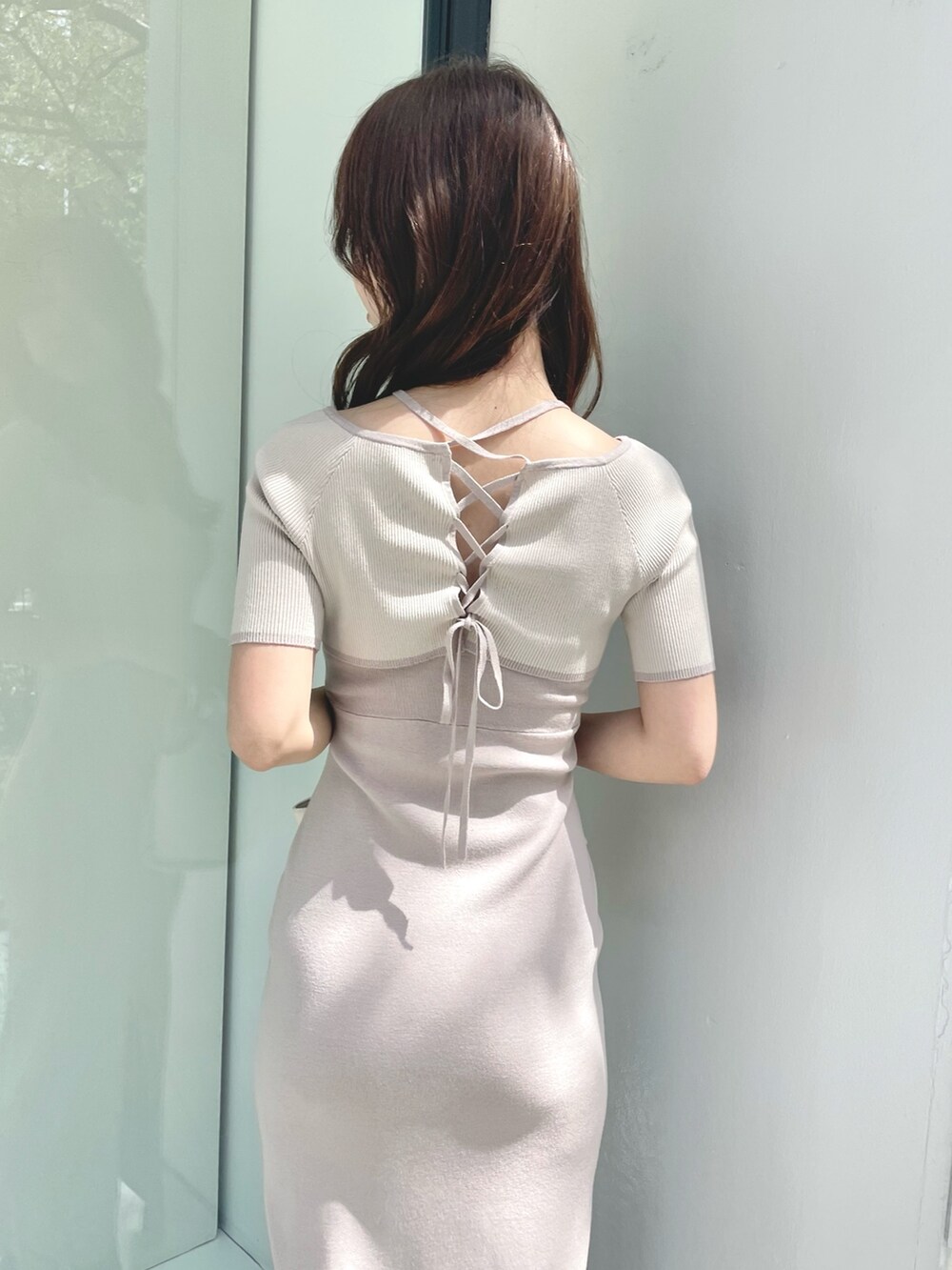 ブラウン系のブーツ、ピンク系のワンピース、ホワイト系のトートバッグを着用したレディースの春コーディネートの5枚目の写真