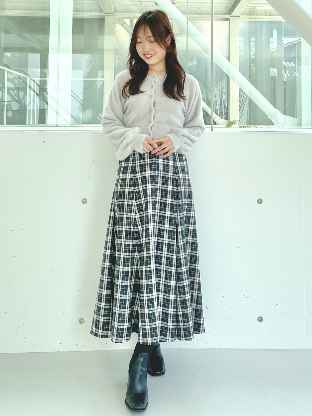 グレー系のカーディガン/ボレロ、ブラック系のスカート、ブラック系のブーツを着用したレディースの秋コーディネートの2枚目の写真