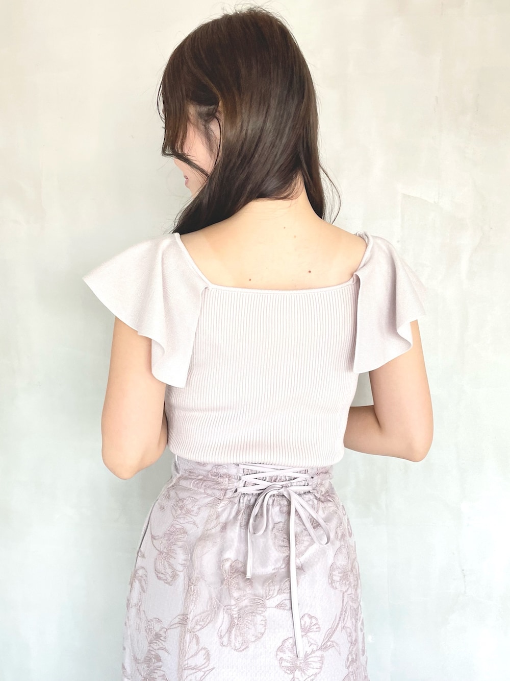 ピンク系のニット/セーター、ピンク系のスカート、ブラウン系のブーツを着用したレディースの春コーディネートの5枚目の写真