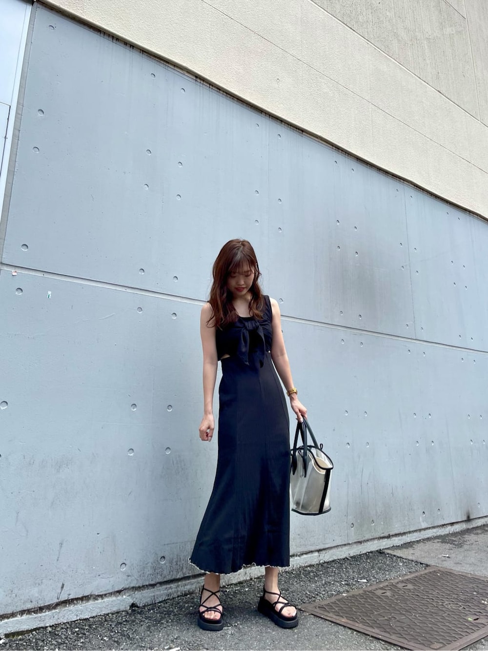 ブラック系のトートバッグ、ブラック系のサンダルを着用したレディースの夏コーディネートの6枚目の写真