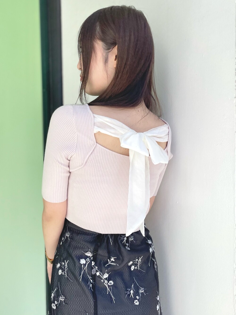 ピンク系のニット/セーター、グレー系のスカート、ホワイト系のサンダルを着用したレディースの春コーディネートの4枚目の写真