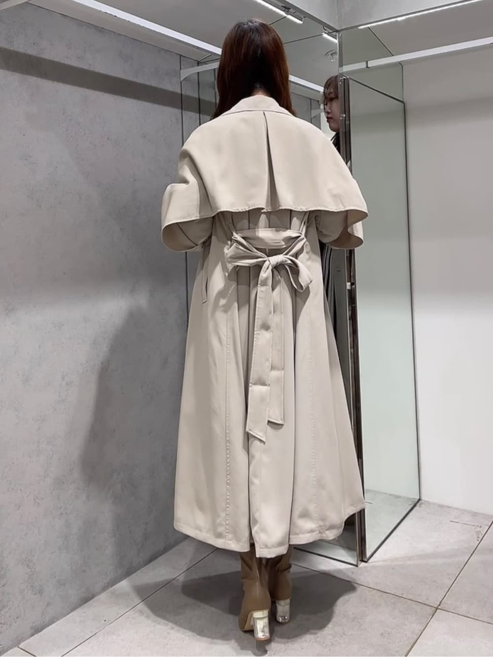 ベージュ系のトレンチコート、ベージュ系のトレンチコート、ホワイト系のワンピースを着用したレディースの秋コーディネートの3枚目の写真