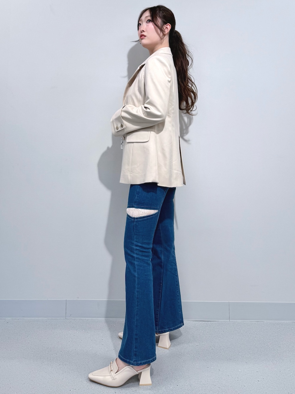 ブルー系のデニムパンツ、ホワイト系のテーラードジャケット、ホワイト系のシャツ/ブラウスを着用したレディースの春コーディネートの2枚目の写真