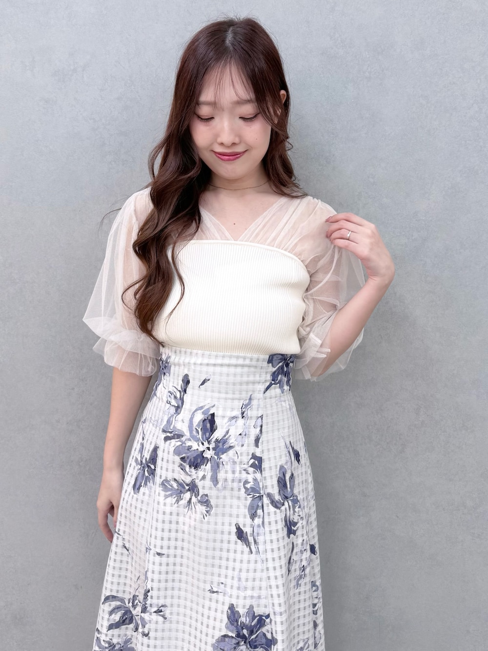 ホワイト系のニット/セーター、シルバー系のサンダル、ブルー系のスカートを着用したレディースの春コーディネートの5枚目の写真