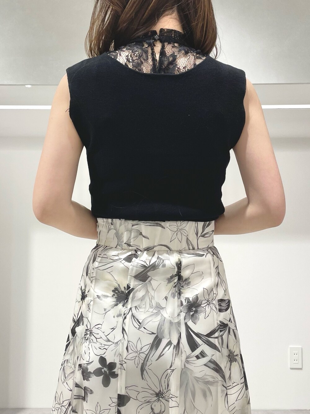 ブラック系のニット/セーター、ホワイト系のスカート、ブラック系のサンダルを着用したレディースの春コーディネートの7枚目の写真