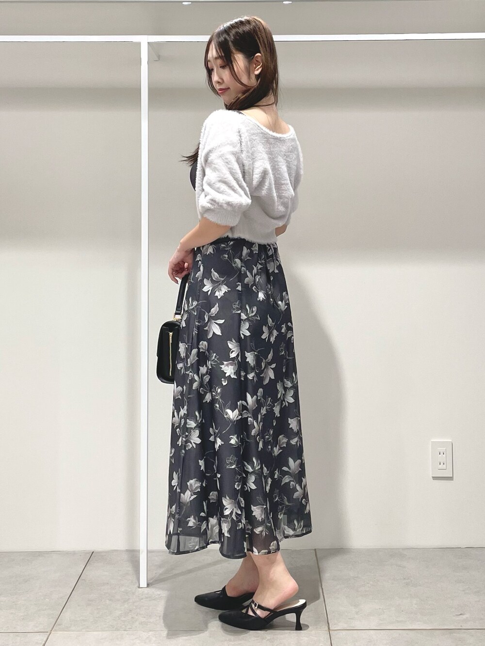 ブラック系のパンプス、ブラック系のショルダーバッグ、グレー系のワンピースを着用したレディースの夏コーディネートの3枚目の写真