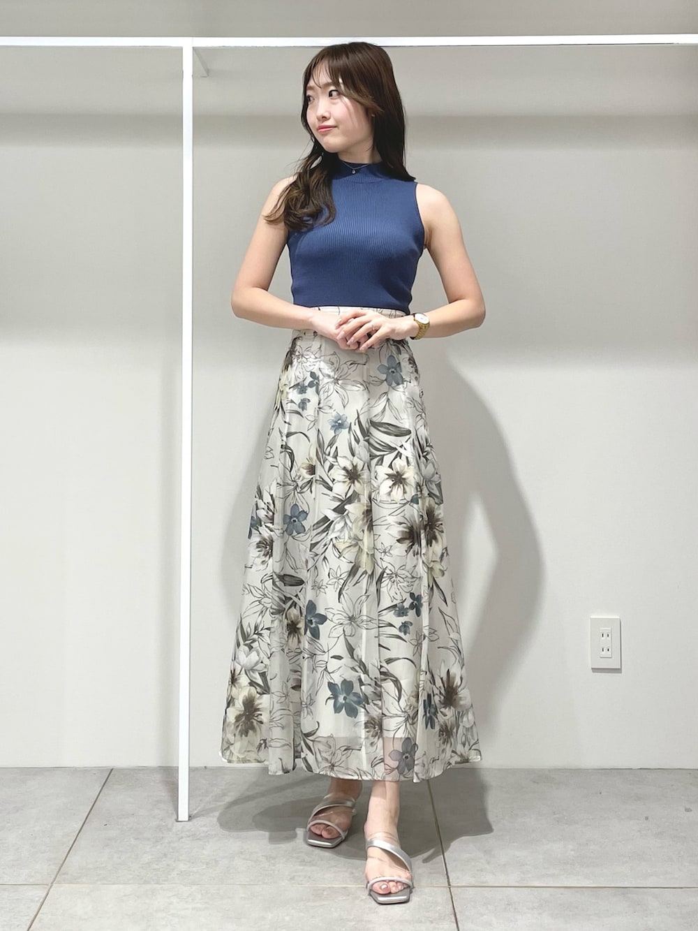 ホワイト系のベスト、グリーン系のスカート、ブルー系のニット/セーターを着用したレディースの春コーディネートの7枚目の写真