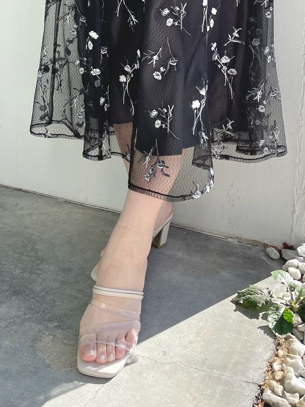 ピンク系のニット/セーター、グレー系のスカート、ホワイト系のサンダルを着用したレディースの春コーディネートの5枚目の写真