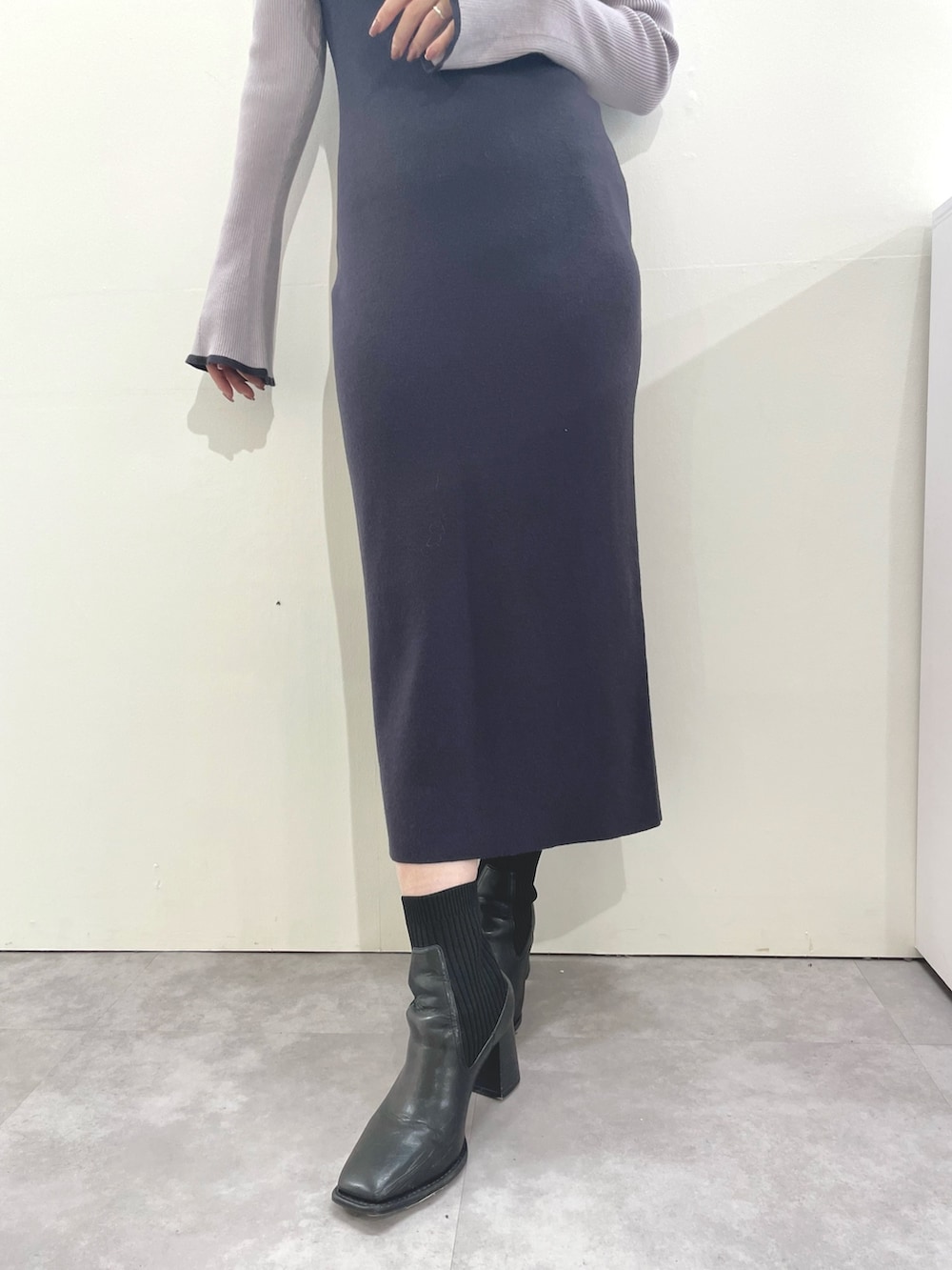 グレー系のワンピース、ブラック系のブーツを着用したレディースの秋コーディネートの8枚目の写真