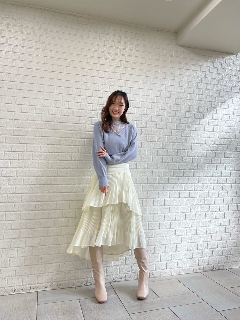 ベージュ系のブーツ、ブルー系のニット/セーター、ホワイト系のスカートを着用したレディースの冬コーディネートの3枚目の写真