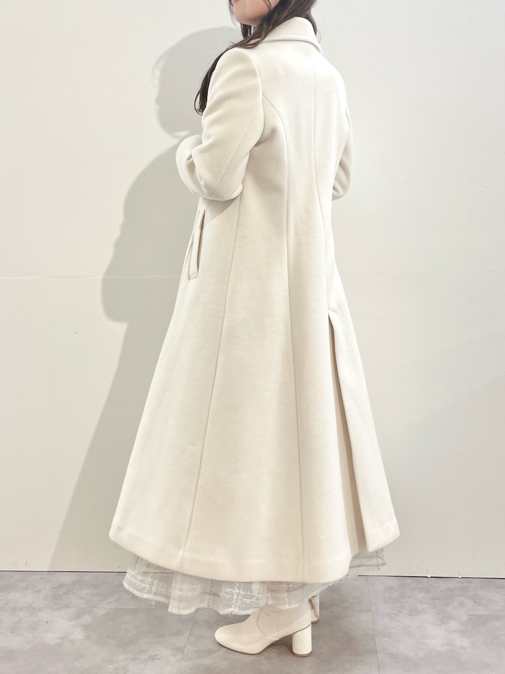 ホワイト系のその他アウター、ホワイト系のスカート、ホワイト系のブーツを着用したレディースの冬コーディネートの2枚目の写真