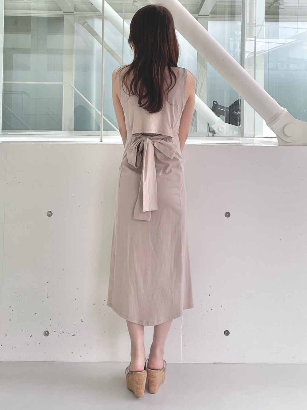 ホワイト系のハンドバッグ、ブラウン系のサンダル、ベージュ系のワンピースを着用したレディースの春コーディネートの4枚目の写真