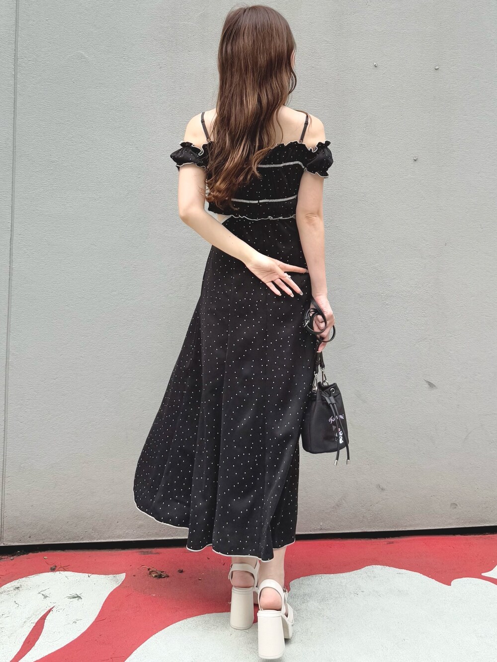 ブラック系のワンピース、ブラック系のショルダーバッグ、ホワイト系のサンダルを着用したレディースの春コーディネートの5枚目の写真