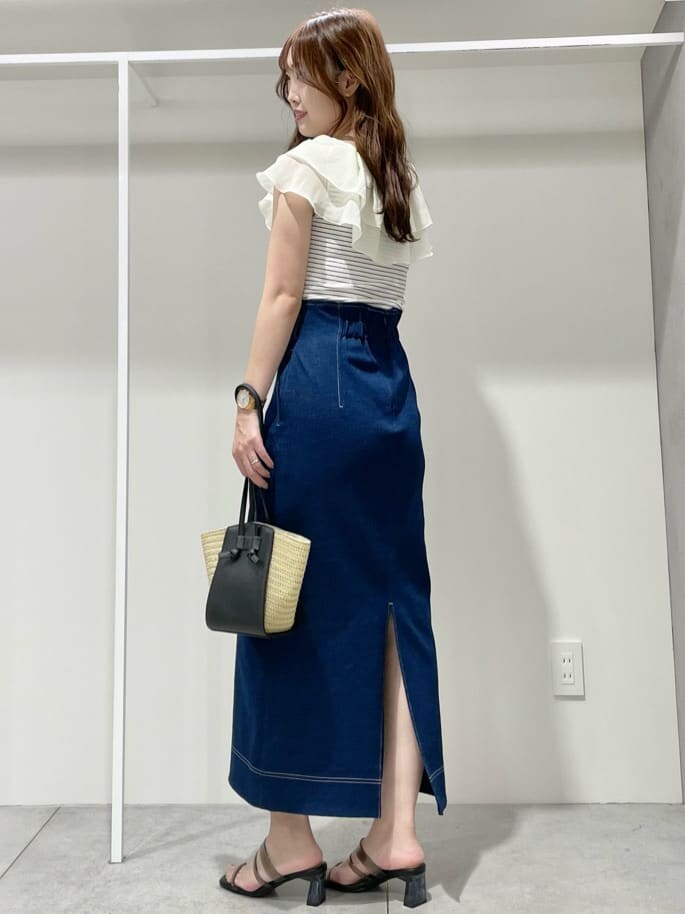 ブラック系のサンダル、ブラック系のトートバッグ、ブルー系のスカートを着用したレディースの夏コーディネートの2枚目の写真