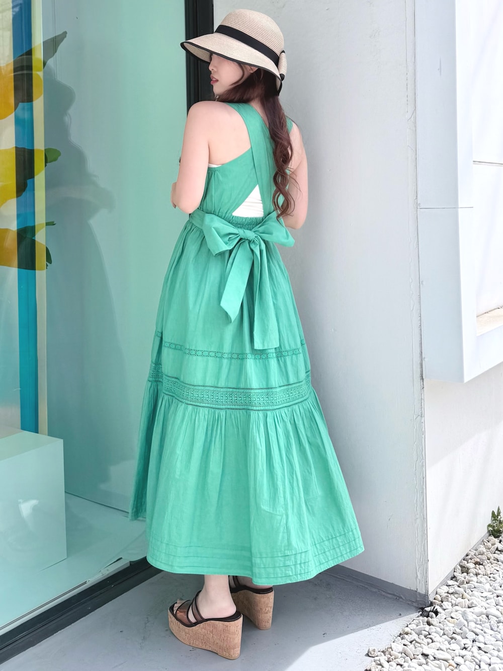 グリーン系のワンピース、ブラウン系のサンダル、ベージュ系のその他雑貨を着用したレディースの春コーディネートの3枚目の写真