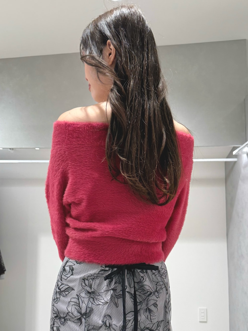 レッド系のニット/セーター、グレー系のハンドバッグ、グレー系のスカートを着用したレディースの秋コーディネートの7枚目の写真