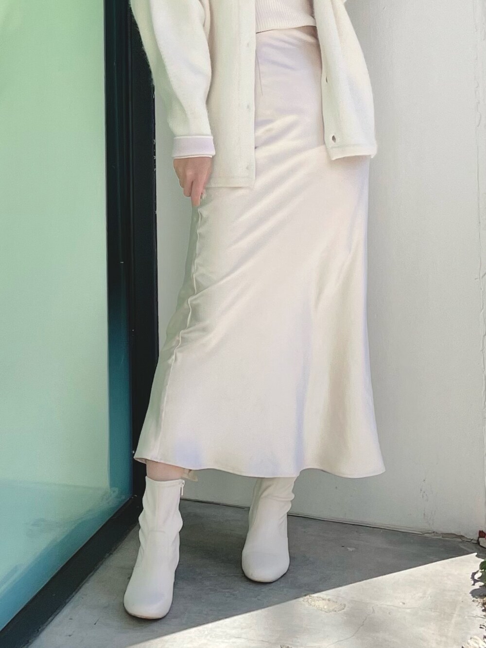 ホワイト系のカーディガン/ボレロ、ホワイト系のニット/セーター、ホワイト系のスカートを着用したレディースの冬コーディネートの7枚目の写真