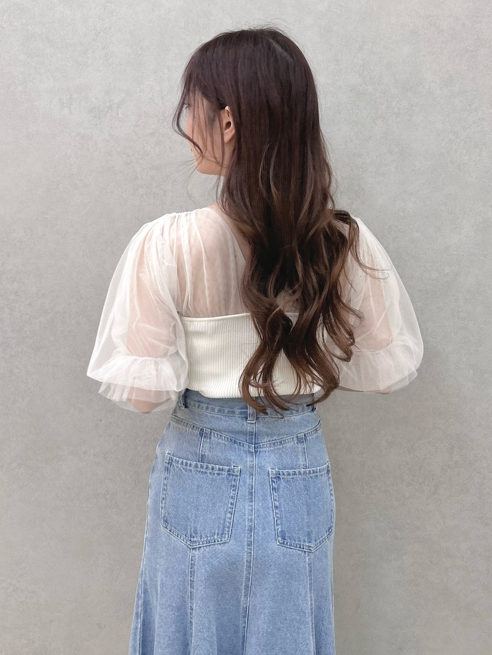 ホワイト系のニット/セーター、ブルー系のスカート、シルバー系のサンダルを着用したレディースの春コーディネートの6枚目の写真