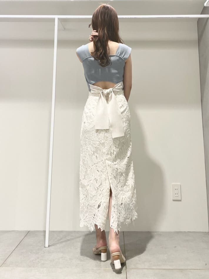 ホワイト系のスカート、ベージュ系のサンダル、ブルー系のニット/セーターを着用したレディースの夏コーディネートの3枚目の写真